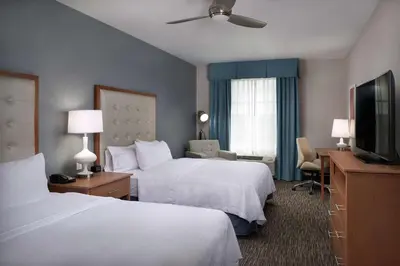 a hotel room with two beds and a flat screen tv at Homewood Suites By Hilton Cincinnati Midtown in Cincinnati