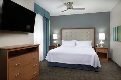 a bedroom with a bed and a flat screen tv at Homewood Suites By Hilton Cincinnati Midtown in Cincinnati