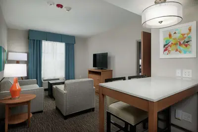 a room with a living room with a couch and a table at Homewood Suites By Hilton Cincinnati Midtown in Cincinnati