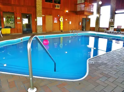a large blue swimming pool in a building at Royalton Inn & Suites Upper Sandusky in Upper Sandusky