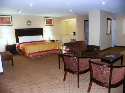 a hotel room with a bed and a couch at Royalton Inn & Suites Upper Sandusky in Upper Sandusky