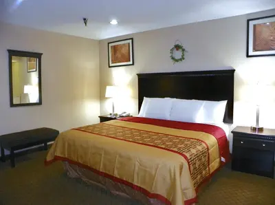 a hotel room with a bed and two lamps at Royalton Inn & Suites Upper Sandusky in Upper Sandusky