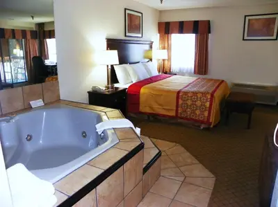 a hotel room with a tub and a bed at Royalton Inn & Suites Upper Sandusky in Upper Sandusky