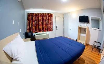 a bedroom with a large blue bed and a window at Anderson Inn, Anderson, Indiana in Anderson