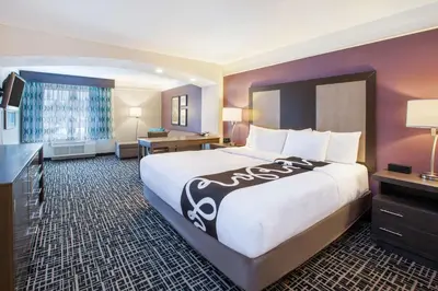 a hotel room with a large bed and a desk at La Quinta by Wyndham Cincinnati Airport Florence in Florence