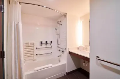 a bathroom with a shower and a tub and a sink at Four Points by Sheraton Cleveland-Eastlake in Eastlake