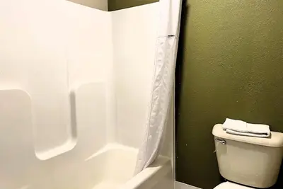 a bathroom with a toilet with a shower curtain at Super 8 by Wyndham Madison IN in Madison
