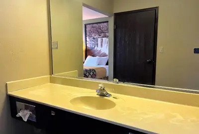 a bathroom with a sink and a large mirror at Super 8 by Wyndham Madison IN in Madison