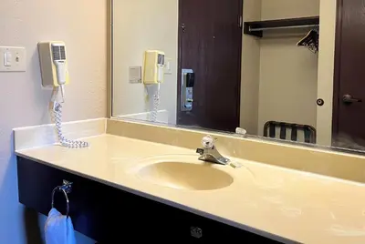 a bathroom with a sink with a mirror and a phone at Super 8 by Wyndham Madison IN in Madison