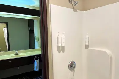 a bathroom with a shower with two bottles on the door at Super 8 by Wyndham Madison IN in Madison
