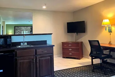 a hotel room with a sink and a desk at Super 8 by Wyndham Madison IN in Madison