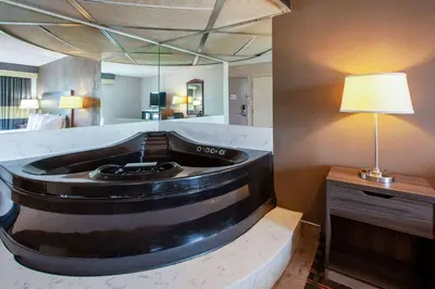 a room with a bath tub in a hotel room at Baymont by Wyndham Northwood in Northwood