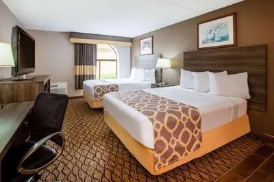a hotel room with two beds and a flat screen tv at Baymont by Wyndham Northwood in Northwood