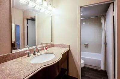 a bathroom with a sink and a toilet and a mirror at Baymont by Wyndham Northwood in Northwood