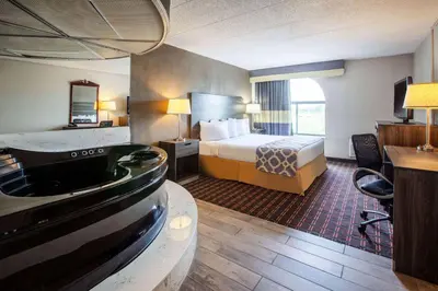 a hotel room with a bed and a bathroom at Baymont by Wyndham Northwood in Northwood