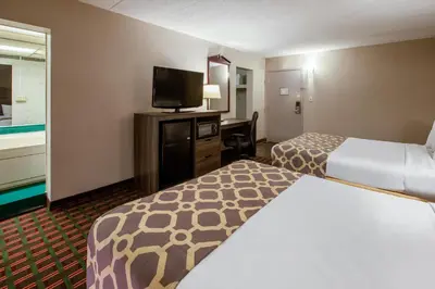 a hotel room with two beds and a flat screen tv at Baymont by Wyndham Northwood in Northwood