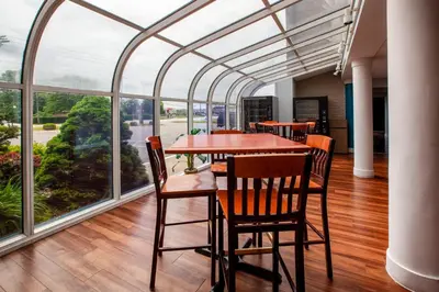a dining room with a table and chairs and large windows at Baymont by Wyndham Northwood in Northwood