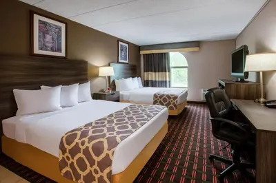 a hotel room with two beds and a desk at Baymont by Wyndham Northwood in Northwood