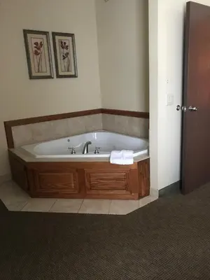 a bathroom with a bath tub in a room at Randolph Inn and Suites in Winchester