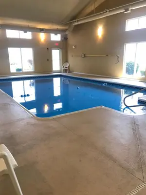 a large swimming pool with blue water in a room at Randolph Inn and Suites in Winchester