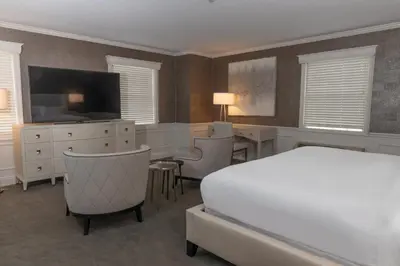 a bedroom with a bed and a desk and a tv at The Grand Resort in Howland Corners