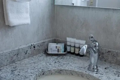 a bathroom counter with a sink and a faucet at The Grand Resort in Howland Corners