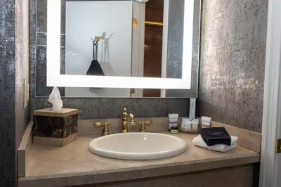 a bathroom sink with a large mirror above it at The Grand Resort in Howland Corners