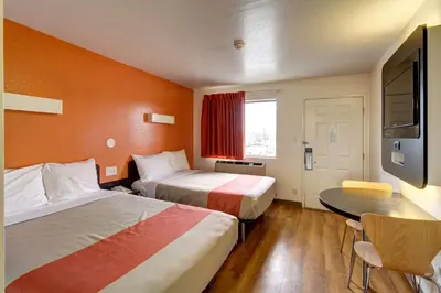 a hotel room with two beds and a table at Motel 6-Amherst, OH - Cleveland West - Lorain in Amherst