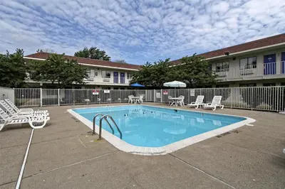 a swimming pool in a courtyard with chairs and tables at Motel 6-Amherst, OH - Cleveland West - Lorain in Amherst