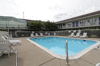 a large swimming pool with chairs and a table at Motel 6-Amherst, OH - Cleveland West - Lorain in Amherst