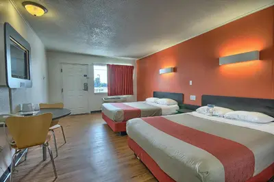 a hotel room with two beds and a table and chairs at Motel 6-Lima, OH in Lima