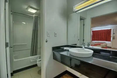 a bathroom with a sink and a toilet and a mirror at Motel 6-Lima, OH in Lima