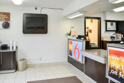 a fast food restaurant with a counter and a tv on the wall at Motel 6-Toledo, OH in Maumee