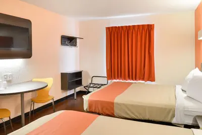 a hotel room with two beds and a table at Motel 6-Toledo, OH in Maumee