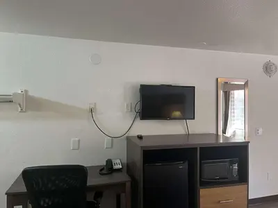 a room with a desk and a tv on a wall at Motel 6 Cross Lanes, WV Goff Mountain Rd in Cross Lanes