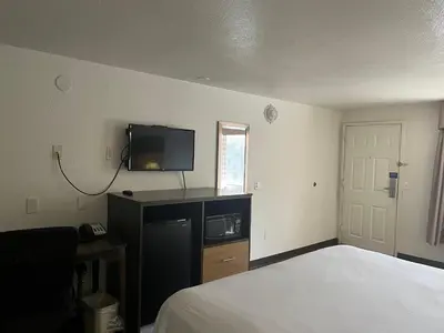 a hotel room with a bed and a tv on a wall at Motel 6 Cross Lanes, WV Goff Mountain Rd in Cross Lanes