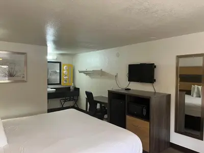 a hotel room with a bed and a desk with a television at Motel 6 Cross Lanes, WV Goff Mountain Rd in Cross Lanes