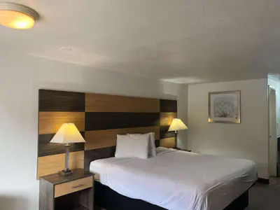 a bedroom with a large bed with a wooden headboard at Motel 6 Cross Lanes, WV Goff Mountain Rd in Cross Lanes