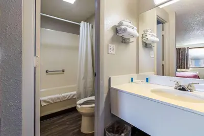 a bathroom with a sink and a toilet and a mirror at Rodeway Inn Near Hall of Fame in Canton