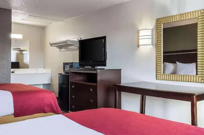 a hotel room with a bed and a flat screen tv at Rodeway Inn Near Hall of Fame in Canton