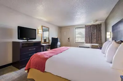a hotel room with a large bed and a flat screen tv at Rodeway Inn Near Hall of Fame in Canton