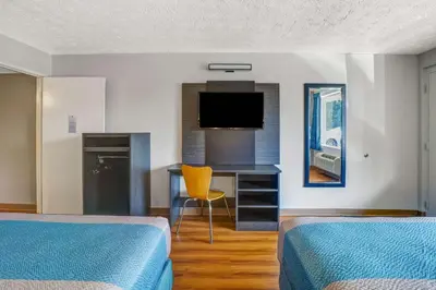 a room with two beds and a desk with a television at Motel 6 Lexington I-75 Hamburg in Lexington