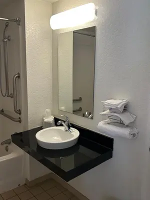 a bathroom with a sink and a mirror at Rodeway Inn Washington PA in Washington