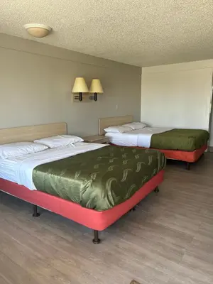 two beds in a hotel room with green covers at Rodeway Inn Washington PA in Washington