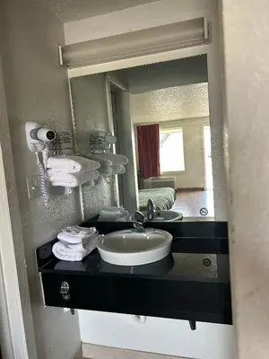 a bathroom with a sink and a large mirror at Rodeway Inn Washington PA in Washington