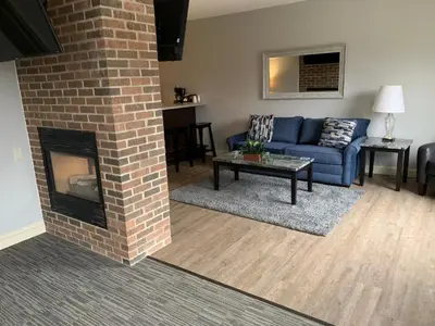 a living room with a blue couch and a brick fireplace at McCoy's Inn in Ripley