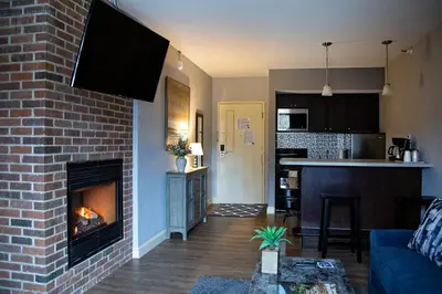 a living room with a brick fireplace and a kitchen at McCoy's Inn in Ripley