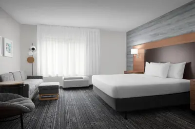 a hotel room with a large bed and a couch at TownePlace Suites Bridgeport Clarksburg in Bridgeport