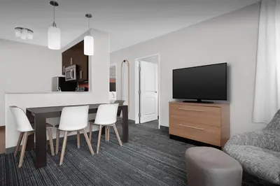 a living room with a dining room table and a television at TownePlace Suites Bridgeport Clarksburg in Bridgeport
