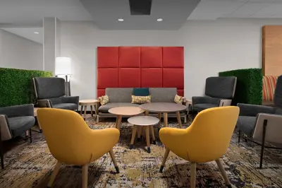 a waiting room with couches and tables and chairs at TownePlace Suites Bridgeport Clarksburg in Bridgeport